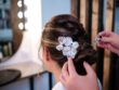 Stylist attachs hair accessories on her client while doing her wedding hairstyle at the hair salon.